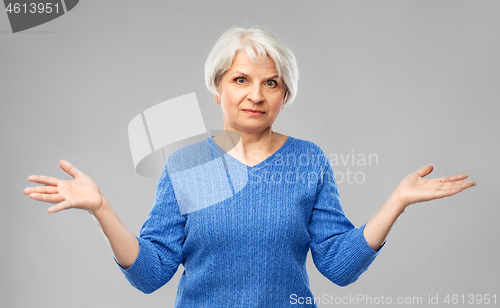 Image of senior woman having no idea and shrugging