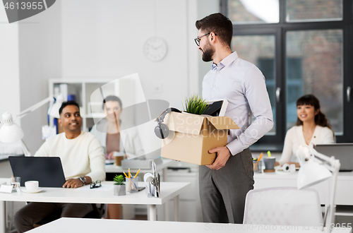 Image of happy male office worker with personal stuff