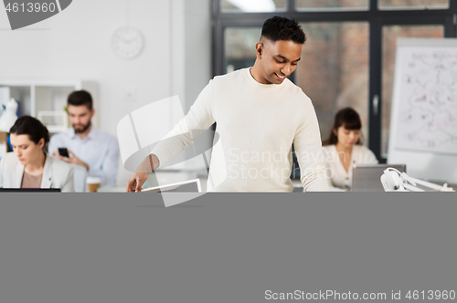 Image of happy male office worker with personal stuff