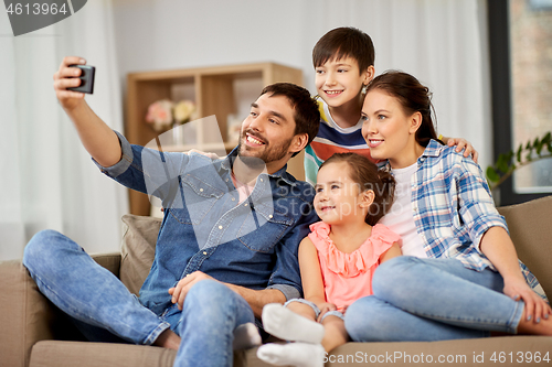 Image of happy family taking selfie at home