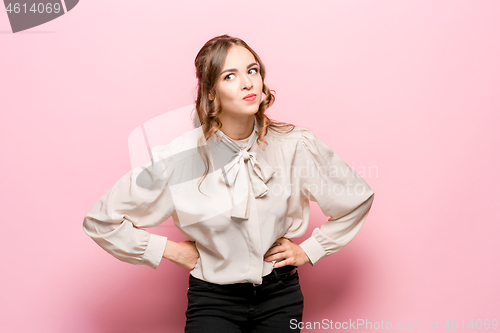 Image of Beautiful female half-length portrait isolated on pink studio backgroud. The young emotional surprised woman