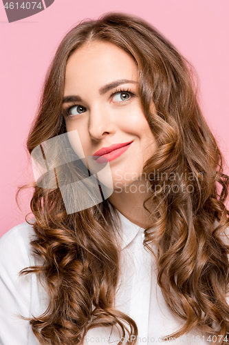 Image of The happy business woman standing and smiling against pink background.