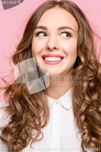 Image of The happy business woman standing and smiling against pink background.