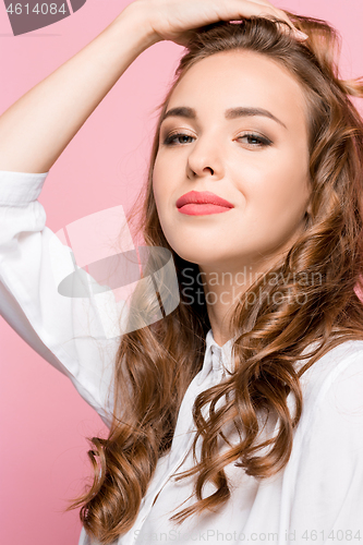 Image of The happy business woman standing and smiling against pink background.