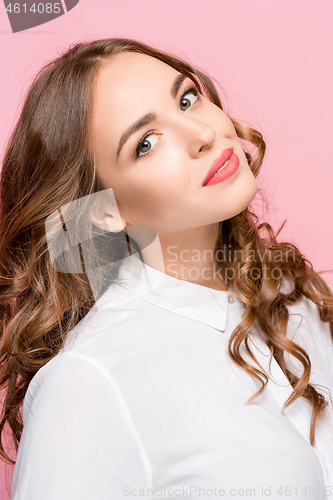 Image of The happy business woman standing and smiling against pink background.