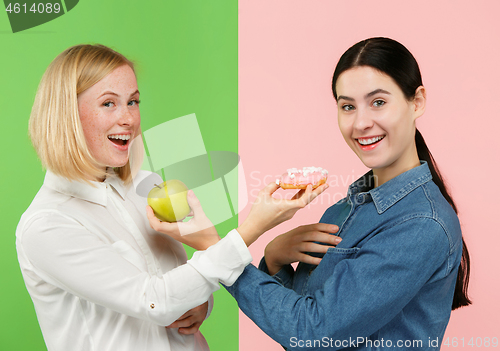 Image of Diet. Dieting concept. Healthy Food. Beautiful Young Women choosing between fruits and unhelathy cake