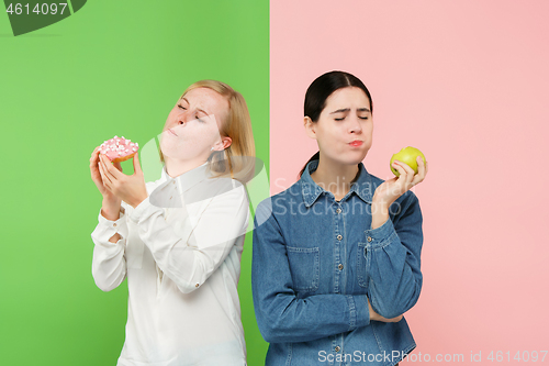 Image of Diet. Dieting concept. Healthy Food. Beautiful Young Women choosing between fruits and unhelathy cake