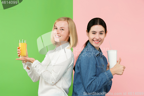 Image of Diet. Dieting concept. Healthy Food. Beautiful Young Women choosing between fruit orange juice and unhelathy carbonated sweet drink