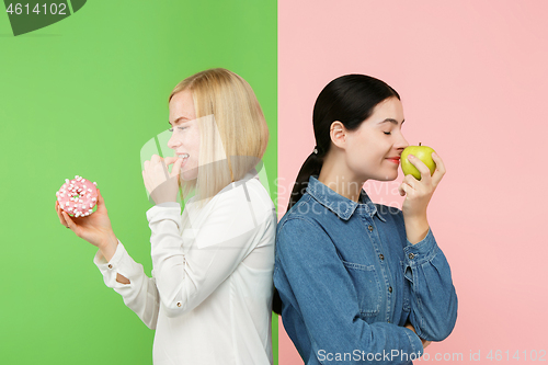 Image of Diet. Dieting concept. Healthy Food. Beautiful Young Women choosing between fruits and unhelathy cake