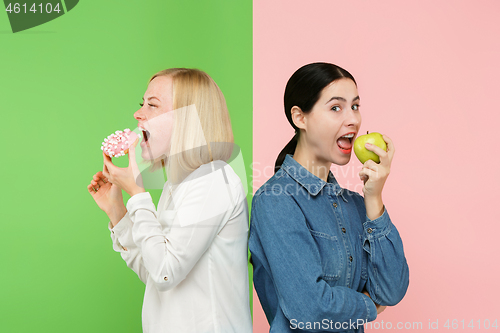 Image of Diet. Dieting concept. Healthy Food. Beautiful Young Women choosing between fruits and unhelathy cake