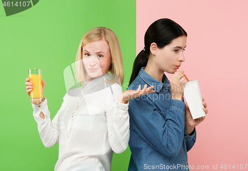 Image of Diet. Dieting concept. Healthy Food. Beautiful Young Women choosing between fruit orange juice and unhelathy carbonated sweet drink