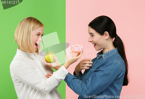 Image of Diet. Dieting concept. Healthy Food. Beautiful Young Women choosing between fruits and unhelathy cake