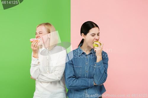 Image of Diet. Dieting concept. Healthy Food. Beautiful Young Women choosing between fruits and unhelathy cake