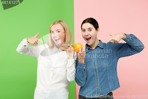 Image of Diet. Dieting concept. Healthy Food. Beautiful Young Women choosing between fruits and unhelathy fast food