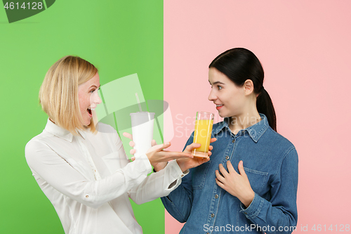 Image of Diet. Dieting concept. Healthy Food. Beautiful Young Women choosing between fruit orange juice and unhelathy carbonated sweet drink