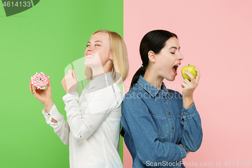 Image of Diet. Dieting concept. Healthy Food. Beautiful Young Women choosing between fruits and unhelathy cake