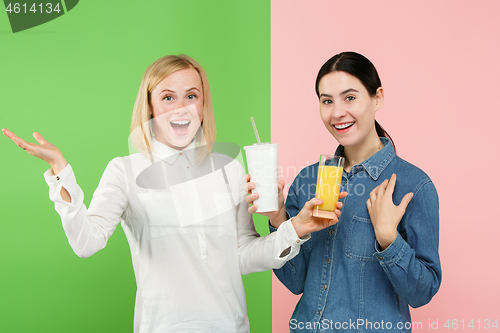 Image of Diet. Dieting concept. Healthy Food. Beautiful Young Women choosing between fruit orange juice and unhelathy carbonated sweet drink