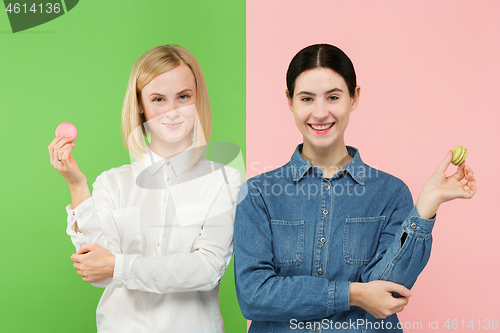 Image of Young beautiful women holding macaroons pastry in her hands