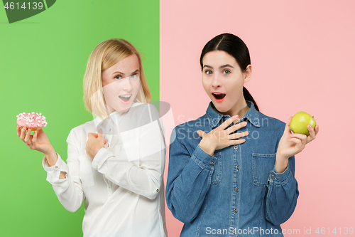 Image of Diet. Dieting concept. Healthy Food. Beautiful Young Women choosing between fruits and unhelathy cake