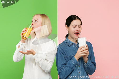 Image of Diet. Dieting concept. Healthy Food. Beautiful Young Women choosing between fruit orange juice and unhelathy carbonated sweet drink