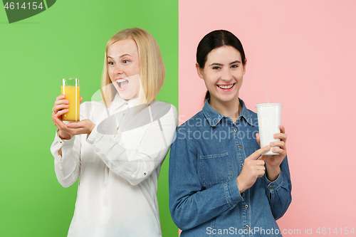 Image of Diet. Dieting concept. Healthy Food. Beautiful Young Women choosing between fruit orange juice and unhelathy carbonated sweet drink