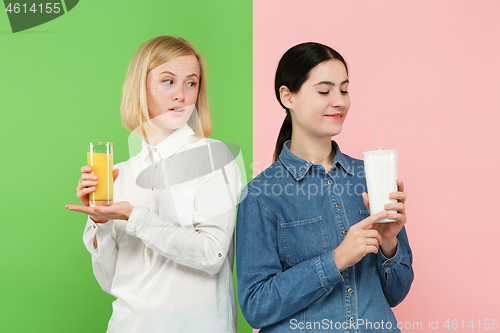 Image of Diet. Dieting concept. Healthy Food. Beautiful Young Women choosing between fruit orange juice and unhelathy carbonated sweet drink