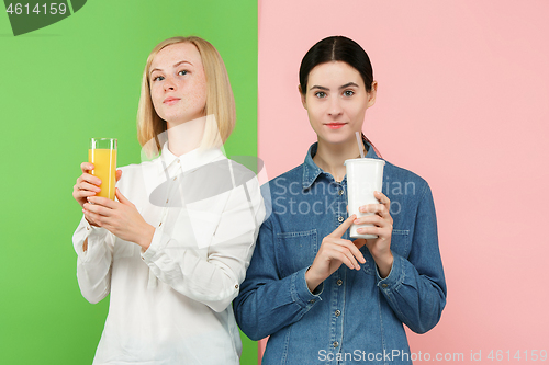 Image of Diet. Dieting concept. Healthy Food. Beautiful Young Women choosing between fruit orange juice and unhelathy carbonated sweet drink