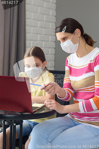 Image of The girl helps the child to do quarantine lessons