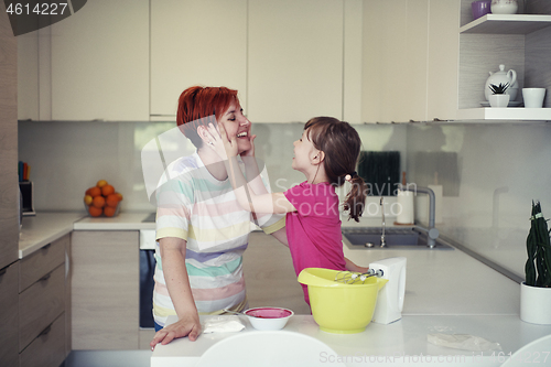 Image of Mother and daughter playing and preparing dough in the kitchen.