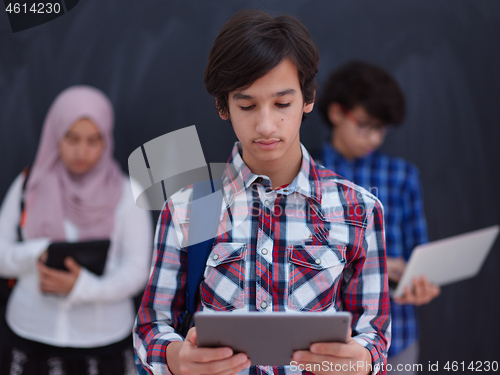 Image of Arab teenagers group working on laptop and tablet computer