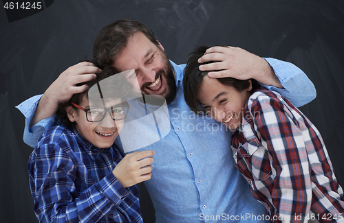 Image of happy father hugging sons