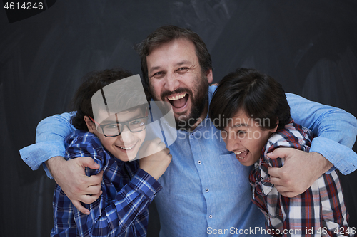 Image of happy father hugging sons