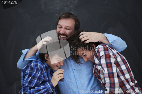 Image of happy father hugging sons