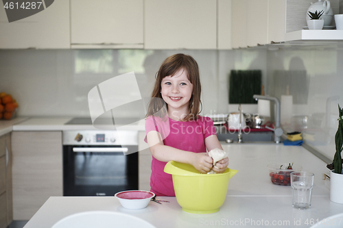 Image of Mother and daughter playing and preparing dough in the kitchen.