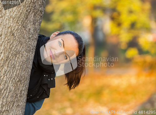 Image of Woman Hiding Behind a Tree