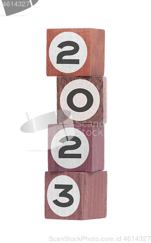 Image of Four isolated hardwood toy blocks, saying 2023