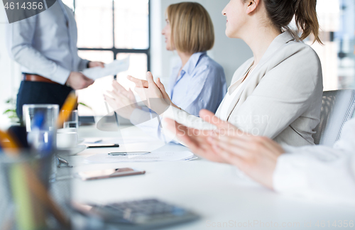 Image of people applauding to colleague at office meeting