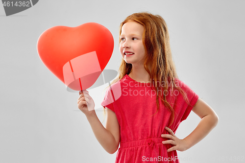 Image of smiling red haired girl with heart shaped balloon