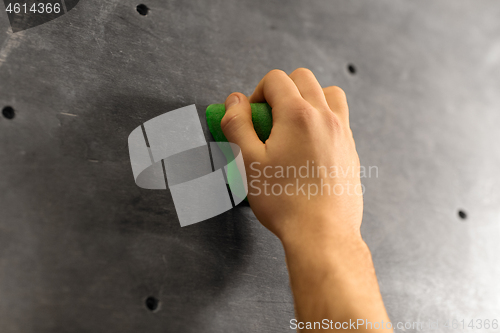 Image of male hand holding to indoor climbing wall