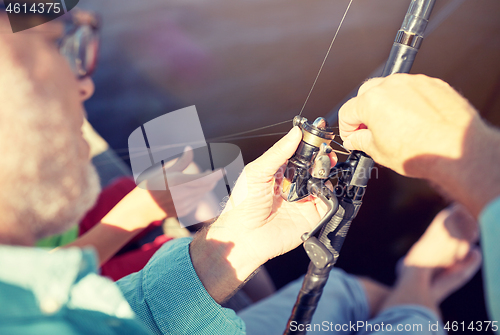 Image of senior man with fishing rod or spinning on river