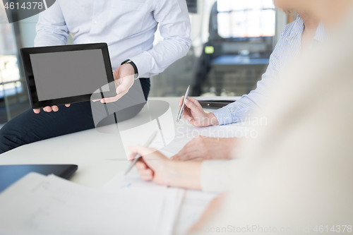 Image of close up of business team with tablet pc at office