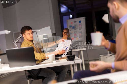 Image of designers or software developers at night office