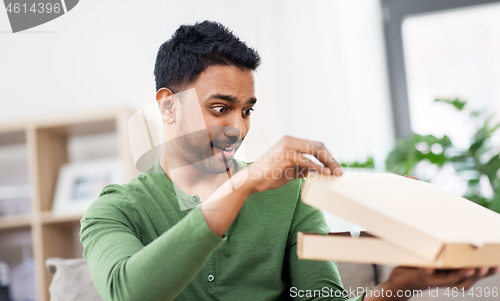 Image of indian man looking inside of takeaway pizza box