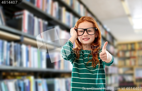 Image of smiling red haired girl in glasses at library