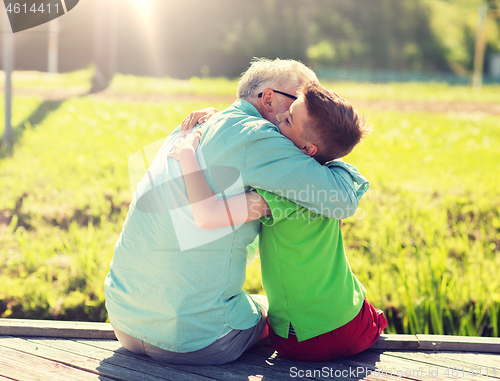 Image of grandfather and grandson hugging on berth