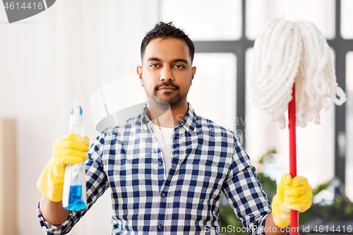 Image of indian man with mop and detergent cleaning at home