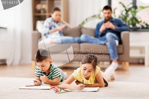 Image of brother and sister drawing with crayons at home