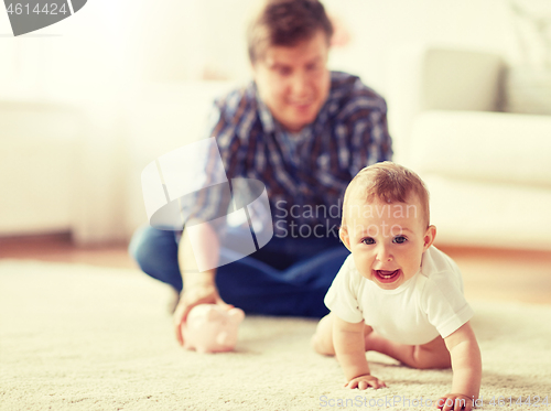 Image of happy father with baby and piggy bank at home