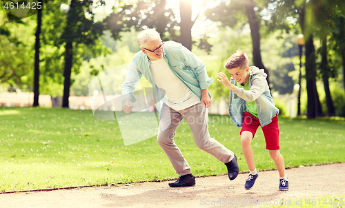 Image of grandfather and grandson racing at summer park