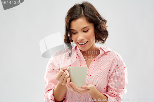 Image of young woman in pajama drinking coffee from mug